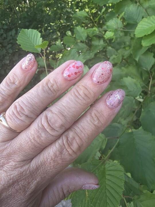 Rosa negler med glitter og kirsebærmotiv, fotografert utendørs
